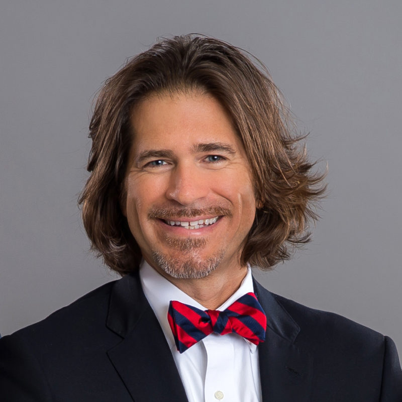 A man with long hair and a bow tie.