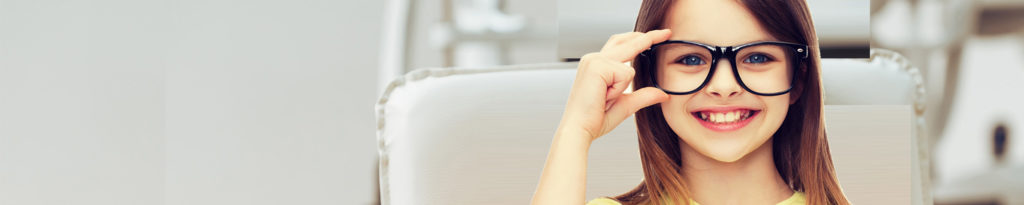 A woman sitting in front of a white wall.