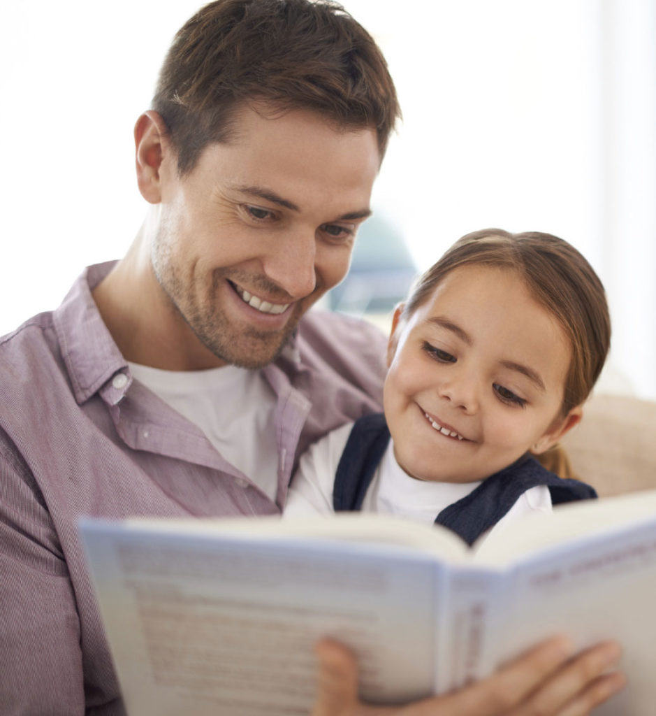 A man and his daughter reading a book.