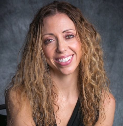 A woman with long hair and a black top.